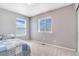 Simple bedroom with cozy carpet and two windows providing plenty of light next to a single bed at 5320 E 100Th Dr, Thornton, CO 80229