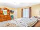 The bedroom includes a large dresser, chair, and patterned bedspread, with good natural light and a TV at 5320 E 100Th Dr, Thornton, CO 80229