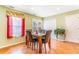 Open dining area with wood floors, room for 4, slider door to backyard, and a large window with stylish curtains at 5320 E 100Th Dr, Thornton, CO 80229