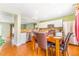 Dining area features wood floors, a wooden table, and views into kitchen with stainless steel appliances at 5320 E 100Th Dr, Thornton, CO 80229