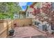 Fenced backyard with brick patio, bordered by garden beds, an air conditioner, and leafy trees at 29 Woodland Cir, Highlands Ranch, CO 80126