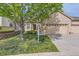 Charming brick home with manicured lawn, mature tree, and a three-car garage at 29 Woodland Cir, Highlands Ranch, CO 80126
