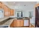 Open kitchen design with granite countertops, oak cabinets and a view to the living area at 29 Woodland Cir, Highlands Ranch, CO 80126