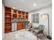 Finished basement bar area features custom cabinets, granite countertop, wine fridge and seating for two at 12690 W 84Th Cir, Arvada, CO 80005