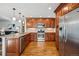 Well-lit kitchen featuring modern stainless steel appliances and wood cabinets at 12690 W 84Th Cir, Arvada, CO 80005