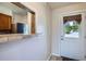 The entrance to the house is a white door, with a view of the kitchen at 1240 S Idalia St, Aurora, CO 80017