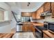 Functional kitchen featuring wood cabinetry, stainless appliances, and tile flooring seamlessly connecting to the living area at 1240 S Idalia St, Aurora, CO 80017