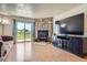 Cozy living room with stone fireplace, hardwood floors, and sliding door access to a balcony at 1240 S Idalia St, Aurora, CO 80017
