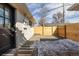 Fenced backyard featuring gravel, a wooden fence, and access to a main building through a black door at 1360 Wolff St, Denver, CO 80204