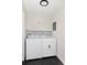 Well-lit laundry room equipped with modern washer and dryer set with storage shelf above at 1360 Wolff St, Denver, CO 80204