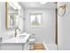 Modern bathroom with a white vanity, toilet, gold fixtures, and a tiled shower at 6500 W 32Nd Ave, Wheat Ridge, CO 80033