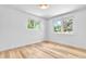 Bright bedroom featuring two windows, light hardwood floors, and fresh white walls at 6500 W 32Nd Ave, Wheat Ridge, CO 80033