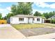 Charming exterior view of a renovated home with a fresh white paint job and landscaped front yard at 6500 W 32Nd Ave, Wheat Ridge, CO 80033