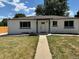 Charming home featuring a covered front porch, white paint, and a well-manicured lawn at 6500 W 32Nd Ave, Wheat Ridge, CO 80033