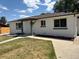 Charming exterior view of the home highlighting its front entrance and well-kept lawn at 6500 W 32Nd Ave, Wheat Ridge, CO 80033