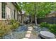 Landscaped backyard featuring a stone walkway, dining table, and a stone sitting area at 2891 E Alameda Ave, Denver, CO 80209