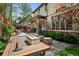 Landscaped backyard with a stone patio, outdoor seating, and a built-in grill area at 2891 E Alameda Ave, Denver, CO 80209