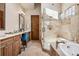 Elegant bathroom featuring a soaking tub, walk-in shower, and dual vanities with a seating area at 2891 E Alameda Ave, Denver, CO 80209