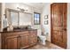 Bathroom featuring a custom vanity, dark marble countertops, and decorative mirror in neutral tones at 2891 E Alameda Ave, Denver, CO 80209