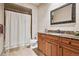 Bathroom features a wood vanity, marble countertops, and shower with shower curtain at 2891 E Alameda Ave, Denver, CO 80209