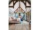 Airy bedroom with exposed beam vaulted ceiling, a fireplace, and access to the outdoor patio at 2891 E Alameda Ave, Denver, CO 80209
