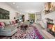 Inviting living room featuring a stone fireplace and cozy seating arrangement with backyard views at 2891 E Alameda Ave, Denver, CO 80209