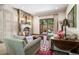 A cozy living room featuring a stone fireplace, plush seating, and access to the outdoor space at 2891 E Alameda Ave, Denver, CO 80209