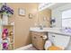 Well-lit bathroom with neutral tones, vanity sink, framed mirror, toilet, and decorative accents at 42 S Moline St, Aurora, CO 80012