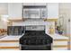 Close-up of kitchen appliances featuring a gas range, microwave, and a white tile backsplash at 42 S Moline St, Aurora, CO 80012