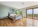 Bright bedroom featuring hardwood floors, a wrought iron bed frame, and a private balcony with scenic views at 2605 Cactus Cir, Golden, CO 80401