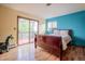 Bright bedroom with wood floors, a sliding glass door to a balcony, and blue accent wall at 2605 Cactus Cir, Golden, CO 80401