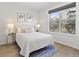 Bright bedroom features a large window and neutral decor for a calm, inviting space at 9019 E Panorama Cir # D204, Englewood, CO 80112