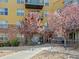 Charming building exterior with blooming trees, complemented by a well-maintained walkway at 9019 E Panorama Cir # D204, Englewood, CO 80112