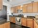 Well-maintained kitchen features granite countertops, stainless steel appliances, and dark tile flooring at 9019 E Panorama Cir # D204, Englewood, CO 80112