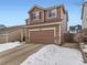 Two-story brown house with a two-car garage and snow-covered driveway at 4936 Stoneham Ave, Castle Rock, CO 80104