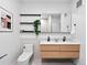 Modern bathroom with a double sink vanity, floating wood drawers, black fixtures, and artful decorations at 1601 Park Ave # 212, Denver, CO 80218