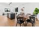 Open dining and kitchen area with dark chairs, natural light, and wood floors at 1601 Park Ave # 212, Denver, CO 80218