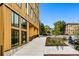 Modern condo building featuring sleek wood paneling and manicured landscaping along a sidewalk with parking at 1601 Park Ave # 212, Denver, CO 80218