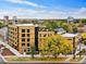 Modern condo building with natural wood exterior, complemented by lush green trees and a vibrant city skyline at 1601 Park Ave # 212, Denver, CO 80218