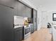 A modern kitchen featuring sleek gray cabinetry, subway tile backsplash, and stainless steel appliances at 1601 Park Ave # 212, Denver, CO 80218