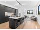 Modern kitchen with black cabinets, a large island with seating, and an open floor plan to the living room at 1601 Park Ave # 212, Denver, CO 80218