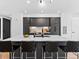 Sleek kitchen island featuring dark cabinetry, a white countertop, and four bar stools at 1601 Park Ave # 212, Denver, CO 80218