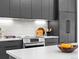 Close-up of a modern kitchen with sleek black cabinets, stainless steel appliances, and a white tile backsplash at 1601 Park Ave # 212, Denver, CO 80218