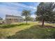 View of the backyard with a covered patio and mature trees and partial fencing at 201 4Th St, Frederick, CO 80530