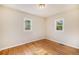 Empty bedroom boasts light walls, glossy hardwood floors, and natural light from two windows at 201 4Th St, Frederick, CO 80530