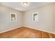 Bedroom featuring light walls, glossy hardwood floors, and dual windows for ample light at 201 4Th St, Frederick, CO 80530