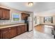 Cozy kitchen features stainless steel refrigerator, decorative backsplash, and light-toned tile floors at 201 4Th St, Frederick, CO 80530