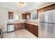 Updated kitchen with tile backsplash, stainless steel appliances and brown cabinetry at 201 4Th St, Frederick, CO 80530