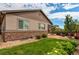 Landscaped backyard featuring lush green lawn, mature trees, and a stone patio at 25144 E Archer Pl, Aurora, CO 80018