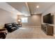 Finished basement with a comfortable leather couch, a large TV, and plush carpeting at 25144 E Archer Pl, Aurora, CO 80018